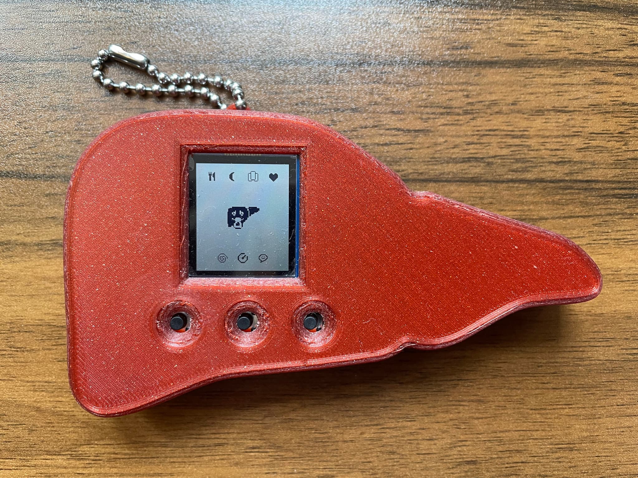 A tamagotchi-like toy, in the shape of a liver with a digital image of a liver on screen in pixel art.